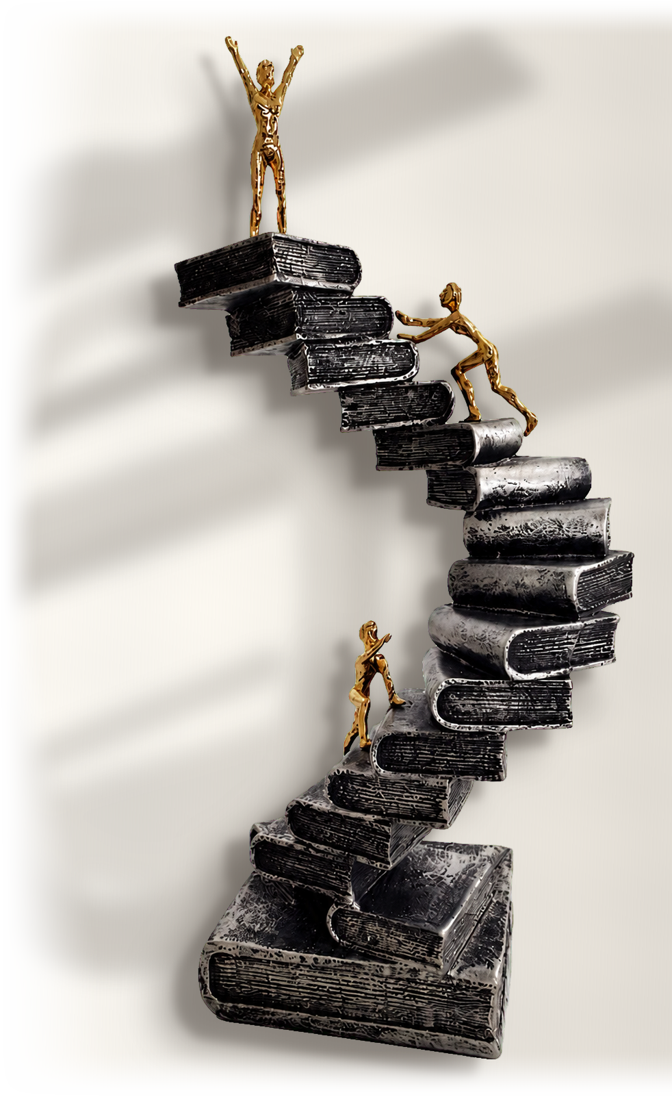 Skulptur mit goldenen Figuren auf einer Treppe aus Büchern